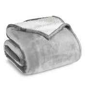 Fleece blanket with white sherpa lining on a white background.