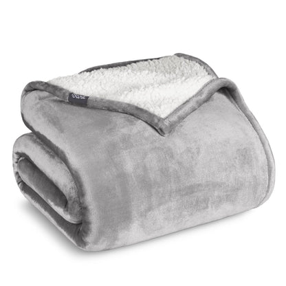 Fleece blanket with white sherpa lining on a white background.