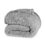 Folded textured blanket with a brand label on a white background