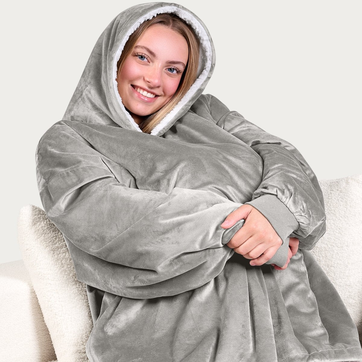 An adult with a hooded wearable blanket on