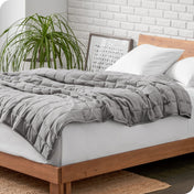 A weighted blanket draped over a bed