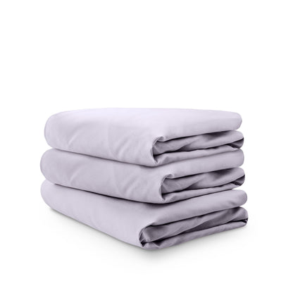 Stack of white folded crib sheets on a white background