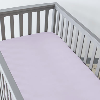 Gray crib with a fitted sheet on the mattress