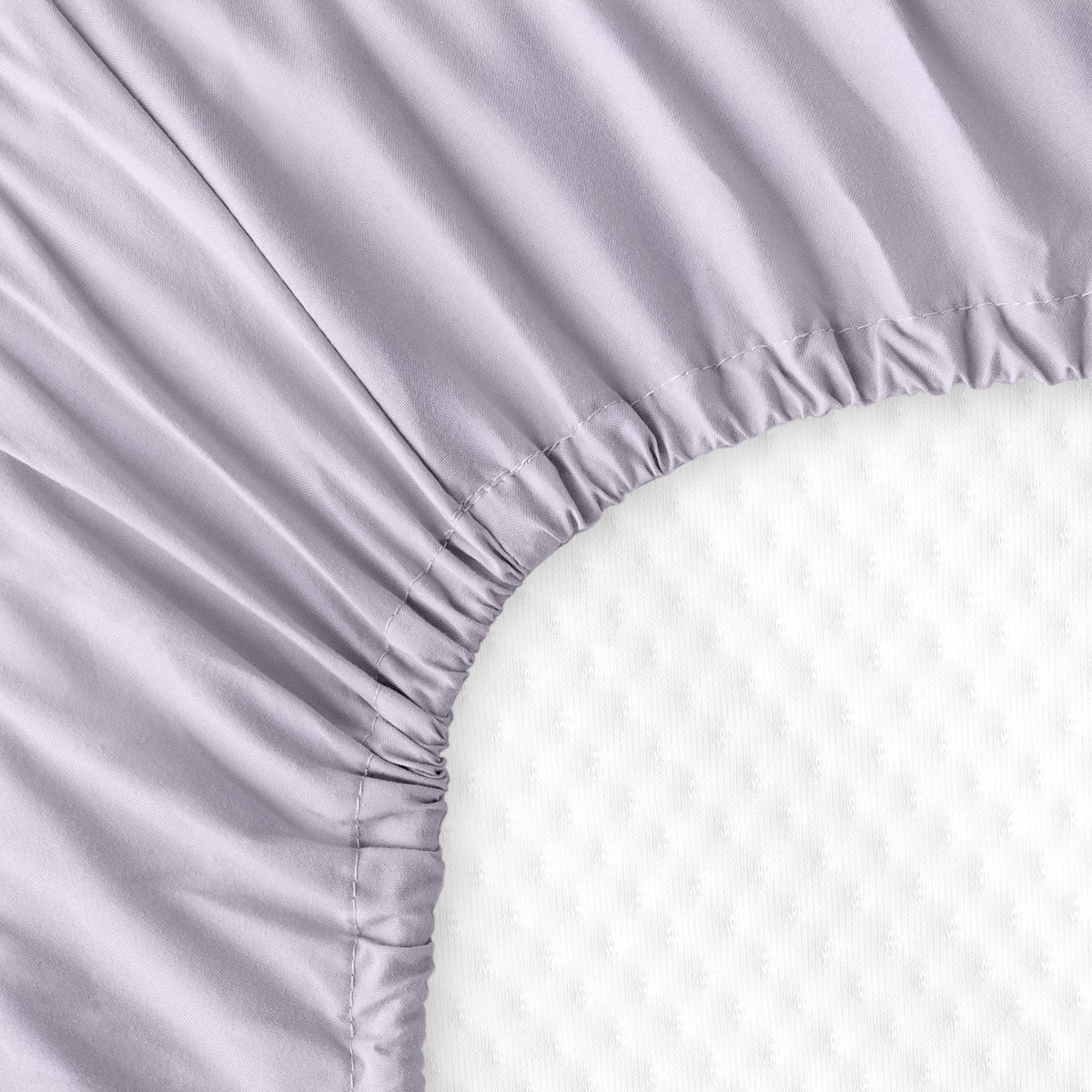 The back of a crib mattress with a fitted sheet on it