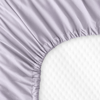 The back of a crib mattress with a fitted sheet on it