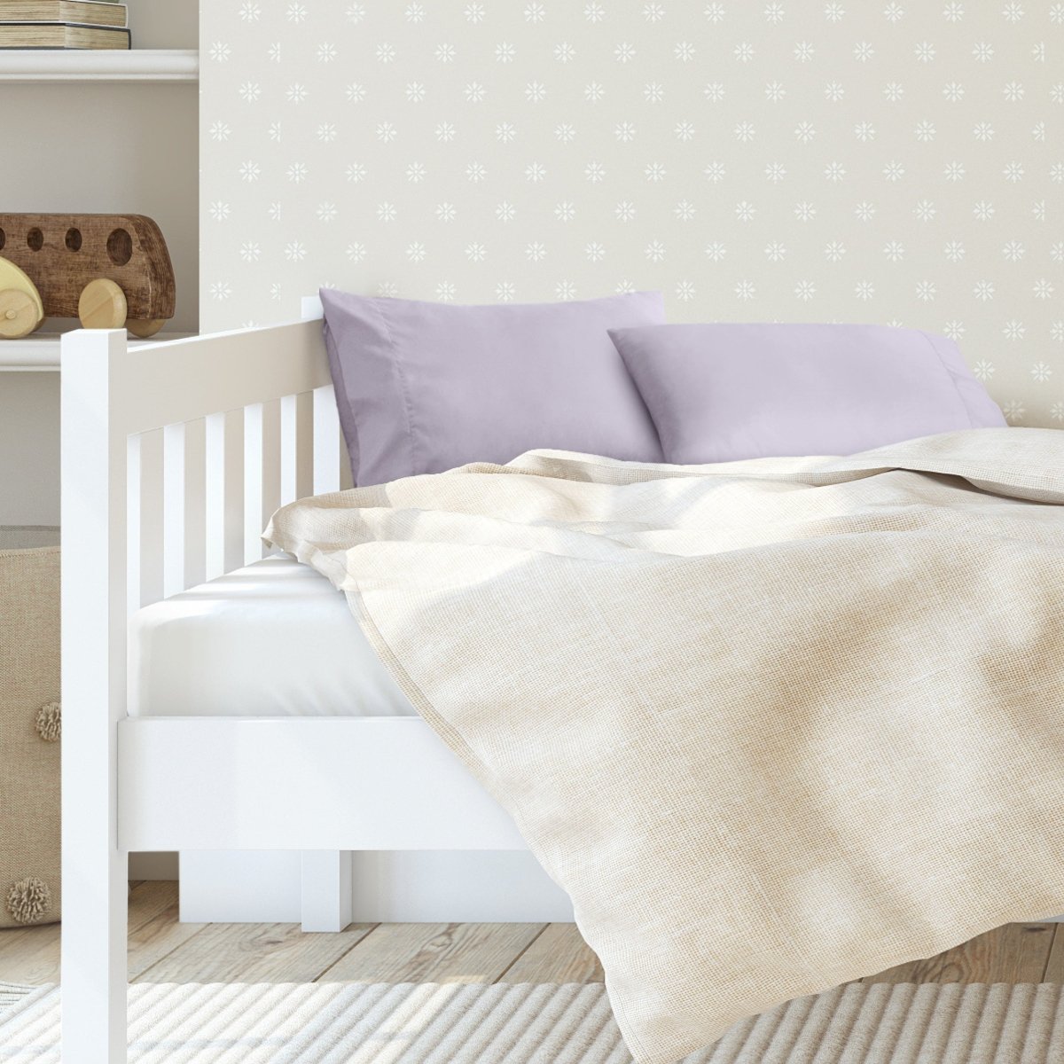 A toddler's bed with 2 microfiber pillowcases on pillows