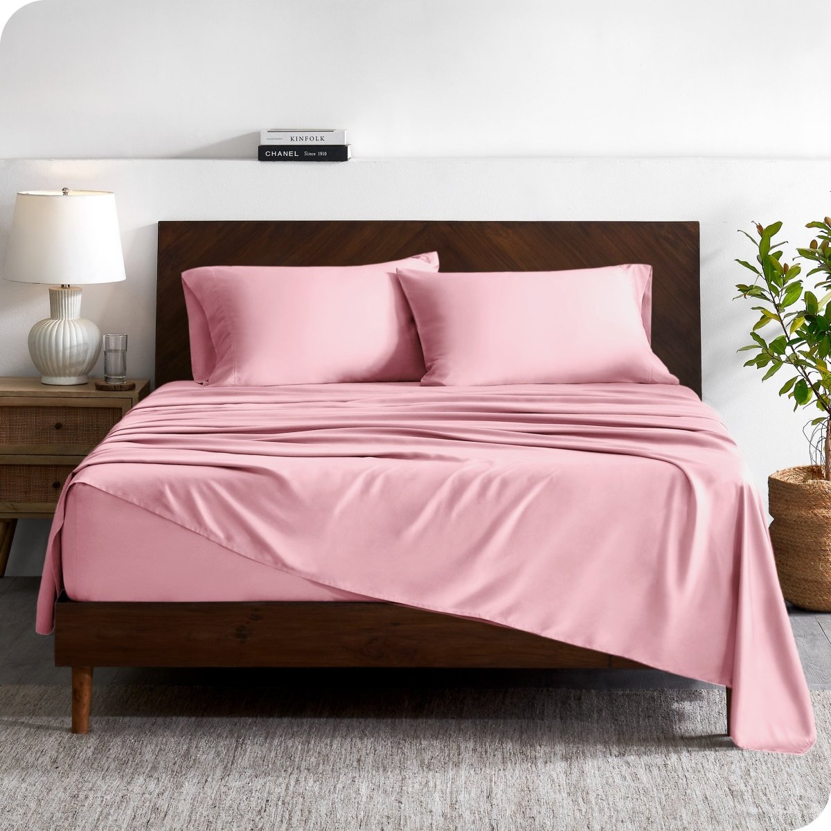 A contemporary bed with a sheet set and a wooden headboard.