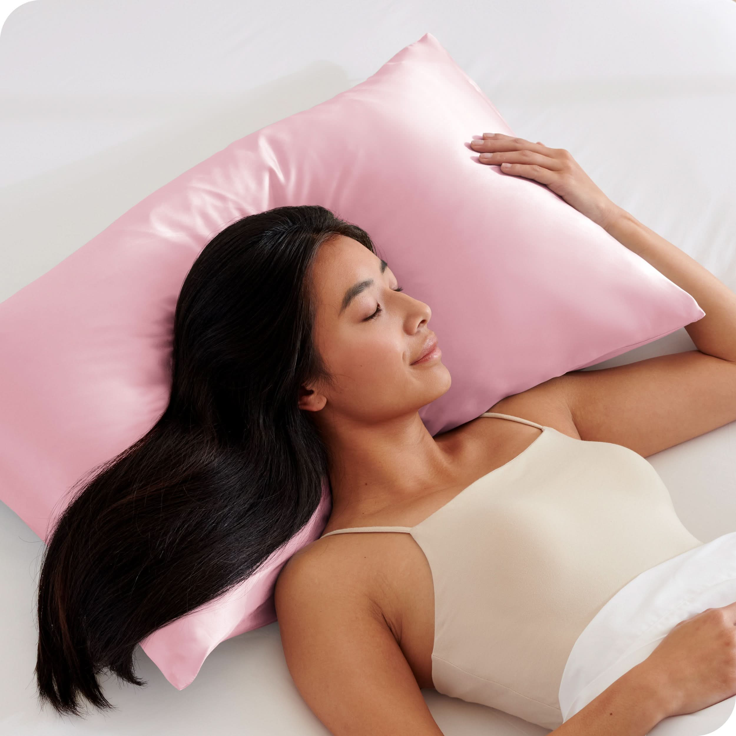 A woman is sleeping with her head on a silk pillowcase