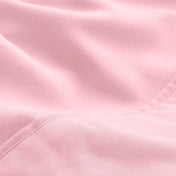 A close-up of microfiber fabric with soft folds and a visible stitched seam.