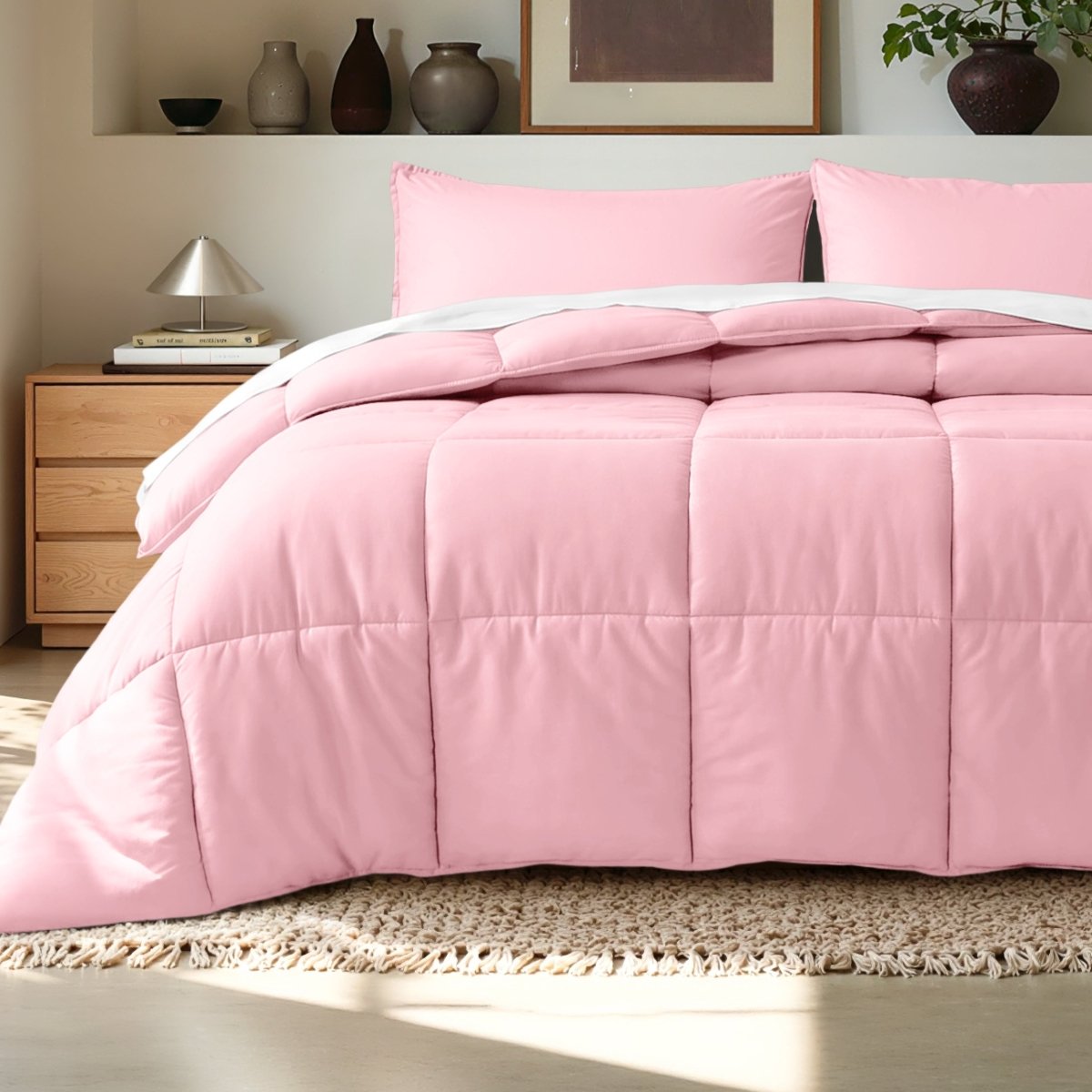 Comforter on a bed in a bedroom setting with a wooden nightstand and decorative items.
