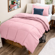 Bed with comforter and pillows in a dorm room