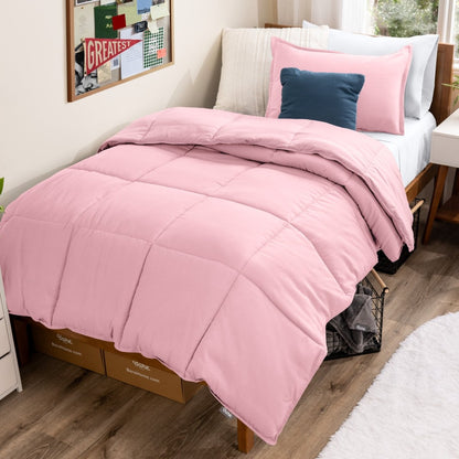 Bed with comforter and pillows in a dorm room