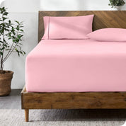 A bed with a fitted sheet and matching pillowcases