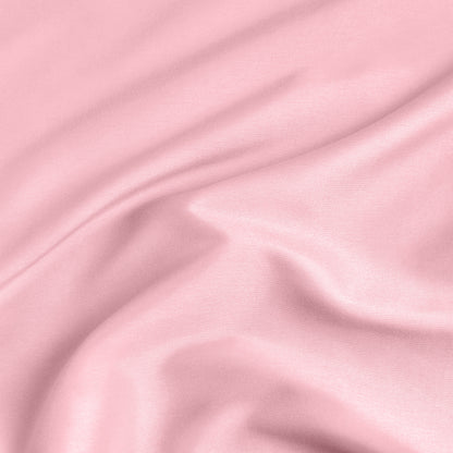 A close-up of a fitted sheet with a label printed with the word 'BOTTOM' in white.