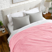 Neatly made bed with a chevron blanket over the comforter