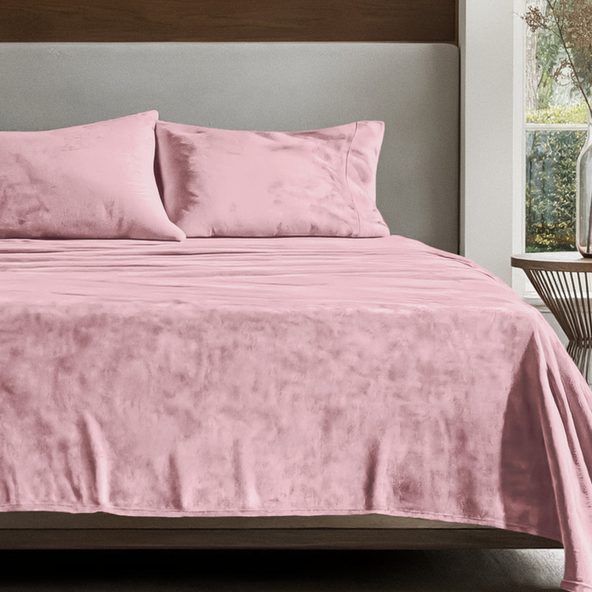 Microplush sheet set on a bed in a bedroom setting with a nightstand and lamp.