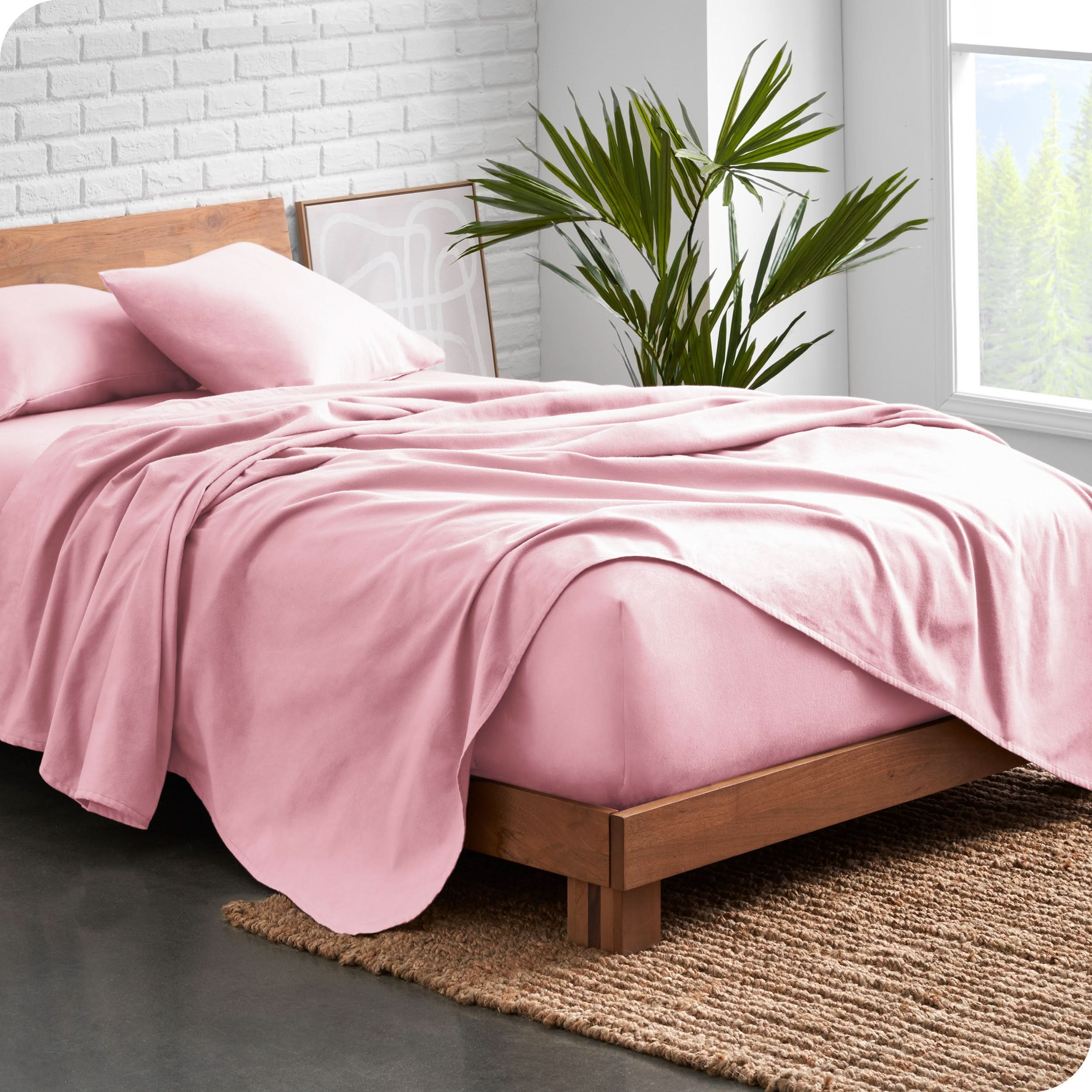 Modern wood bed frame with pink organic flannel sheets and pillowcases