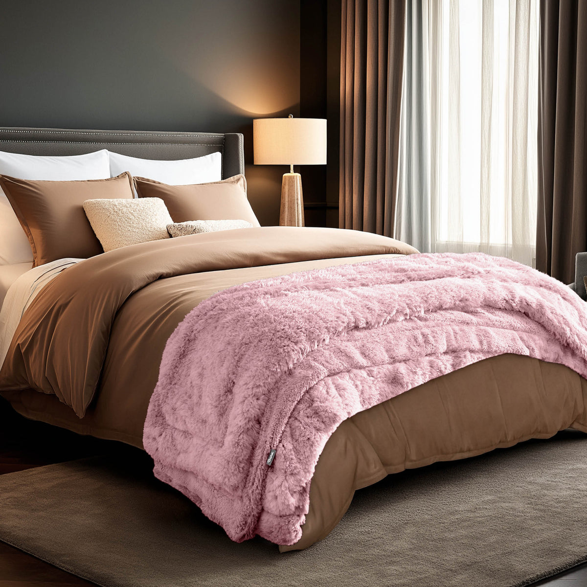 A shaggy faux fur blanket at the end of a bed
