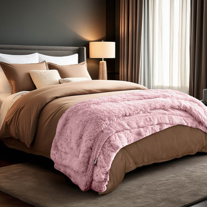 A shaggy faux fur blanket at the end of a bed