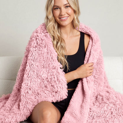 A woman sitting with a shaggy blanket wrapped around her