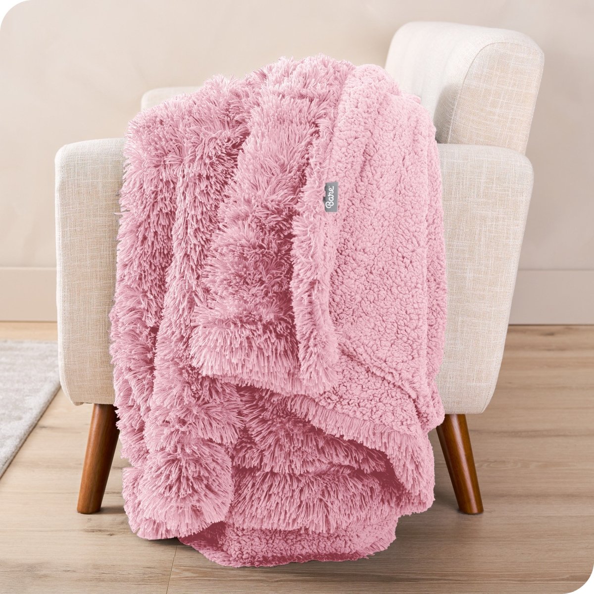 A shaggy faux fur blanket draped over the arm of a chair