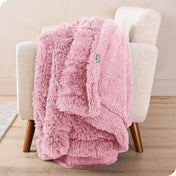 A shaggy faux fur blanket draped over the arm of a chair