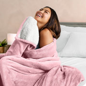 A woman smiling while wrapped in a sherpa blanket