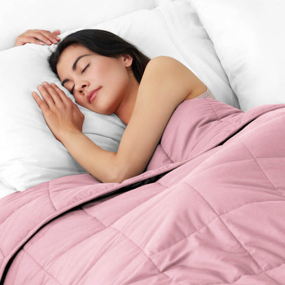 Woman sleeping peacefully under a weighted blanket with white pillows