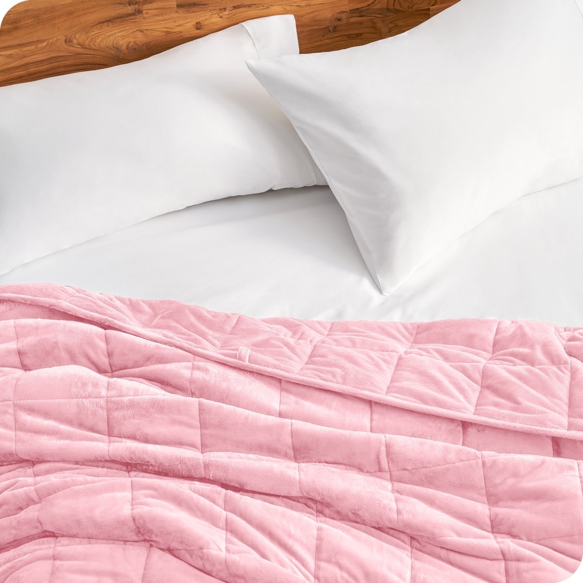 Close up of a weighted blanket on a bed next to pillows