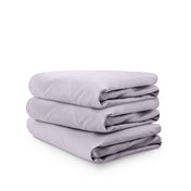 Stack of folded crib sheets on a white background