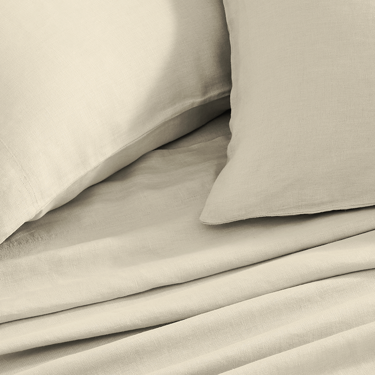 Beige bedding set with two pillows on a bed.