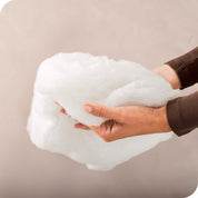 A woman holding the hollow fiber fill of a pillow