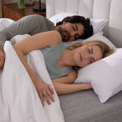 Couple sleeping peacefully in a bedroom setting.