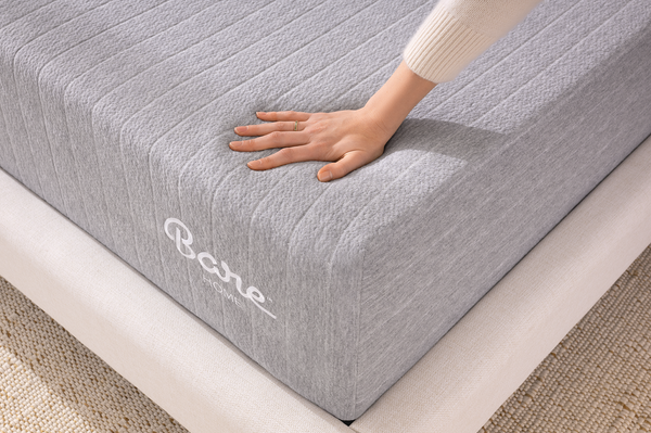 Hand pushing down on a Bare Home Mattress