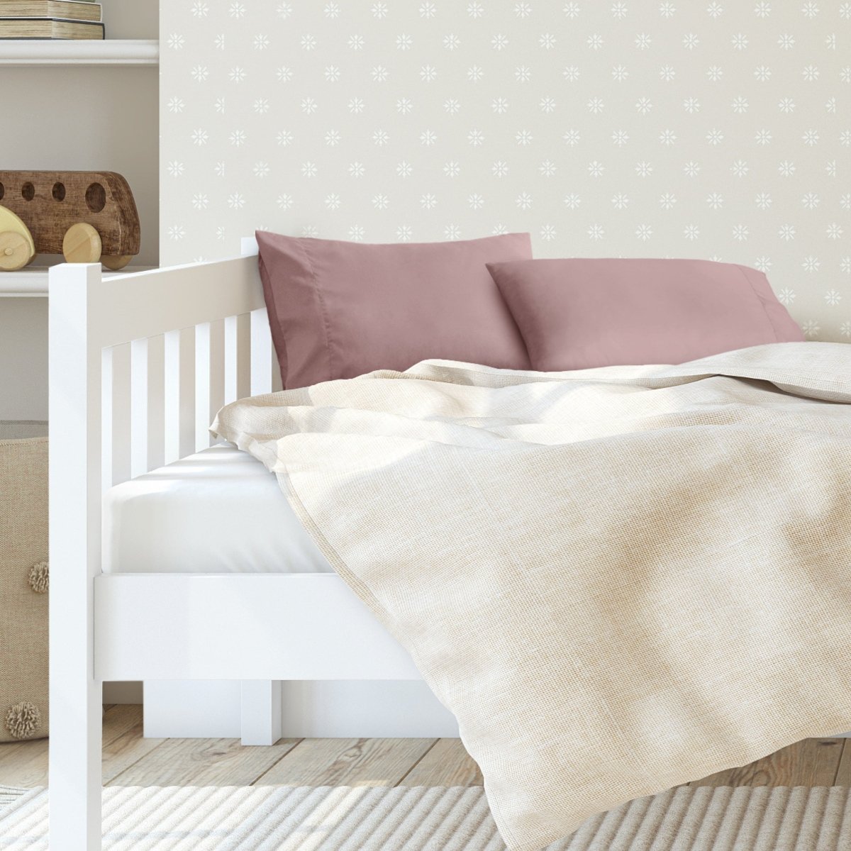 A toddler's bed with 2 microfiber pillowcases on pillows