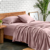 Bed with microfiber sheets against a white brick wall