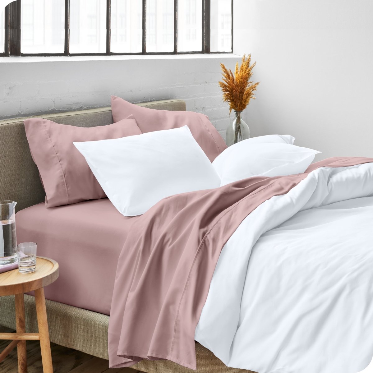 A side view of a bed made with microfiber sheets and a white duvet cover