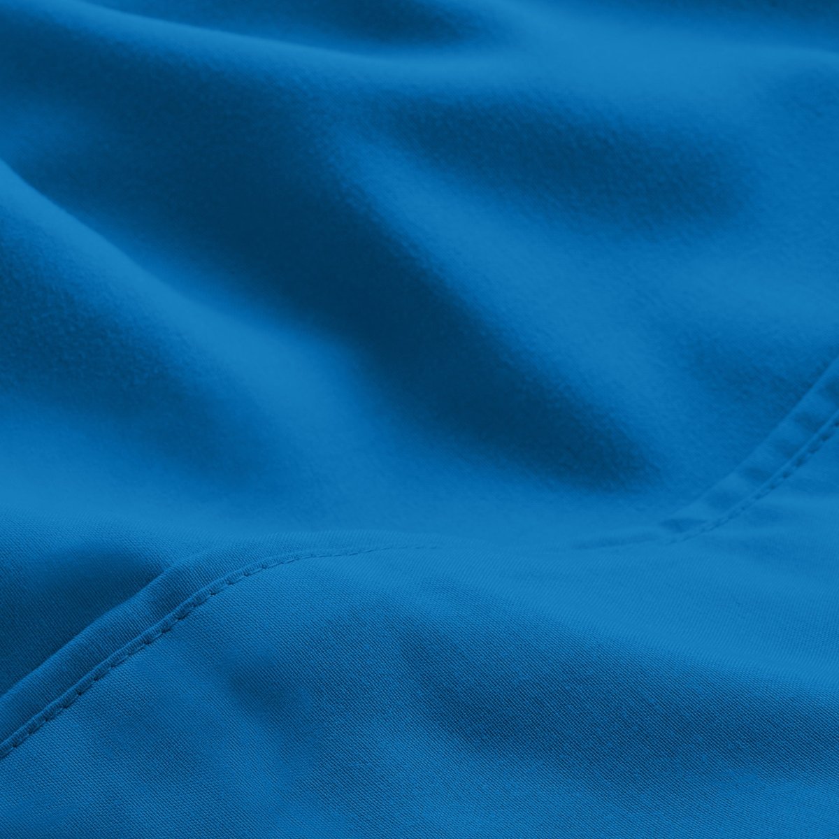 A close-up of microfiber fabric with soft folds and a visible stitched seam.