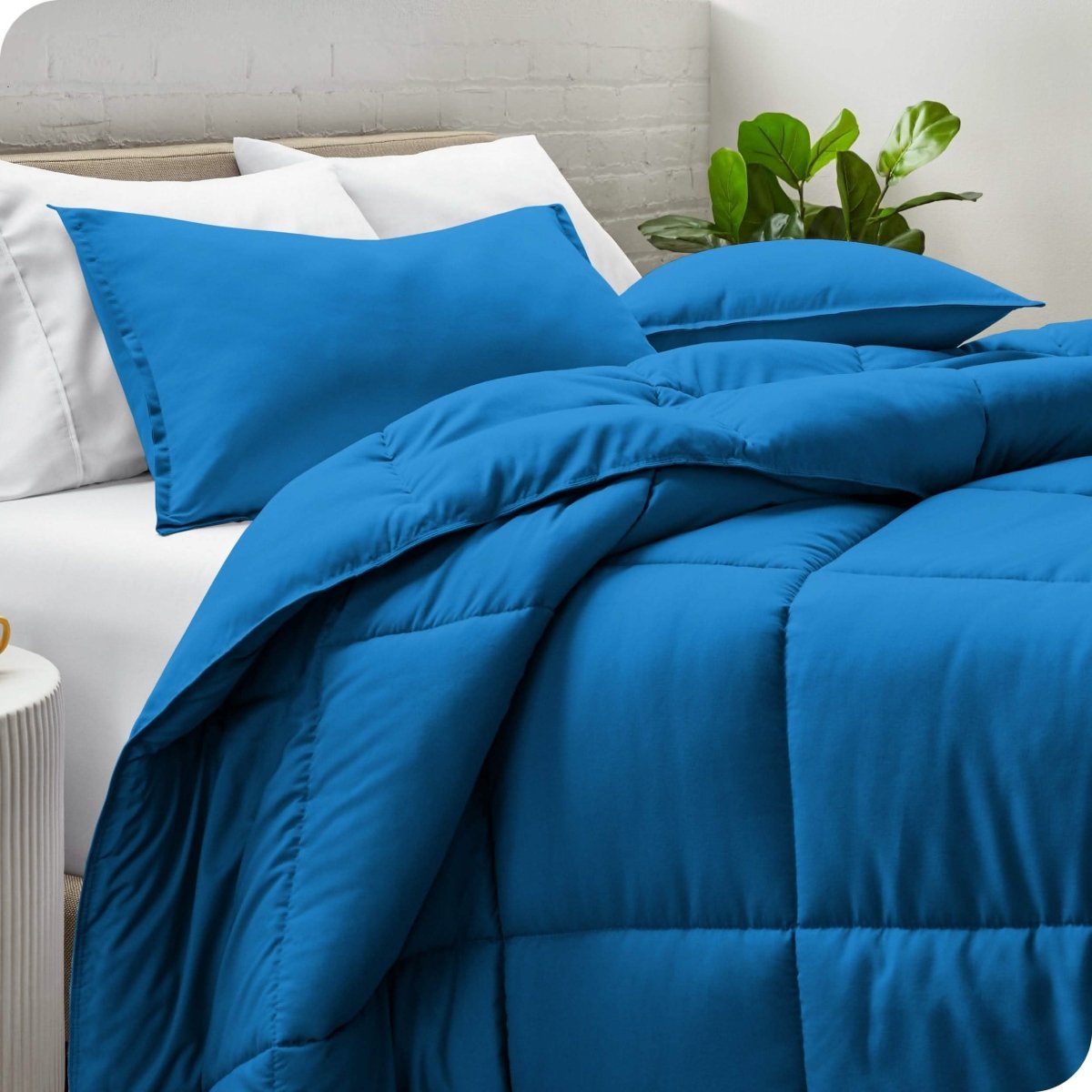 A side view of a modern bed with a comforter set and pillows on the bed