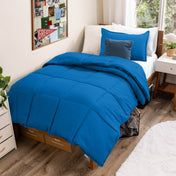 Comforter set on a bed in a bedroom with a window and decor.