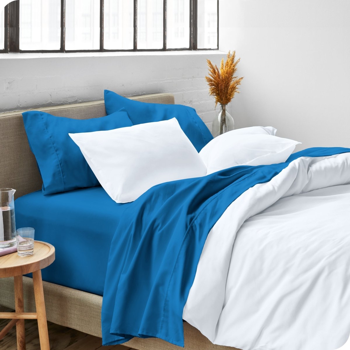 A side view of a bed made with microfiber sheets and a white duvet cover