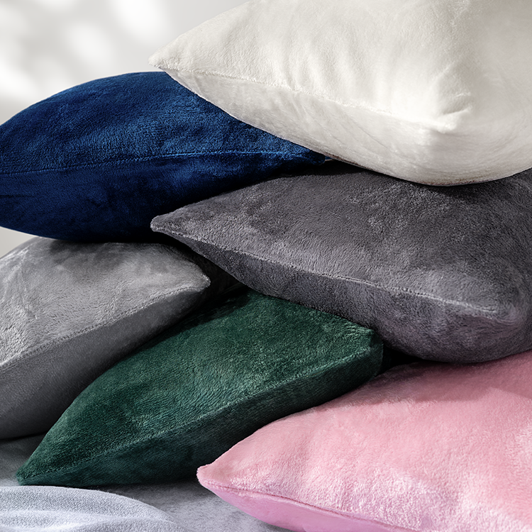 Stack of multicolored pillows on a neutral background