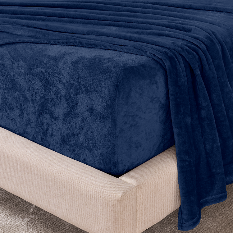 Navy blue blanket draped over a beige bed frame