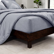 The  corner of a bed with a matching sheet set and comforter set on the bed.