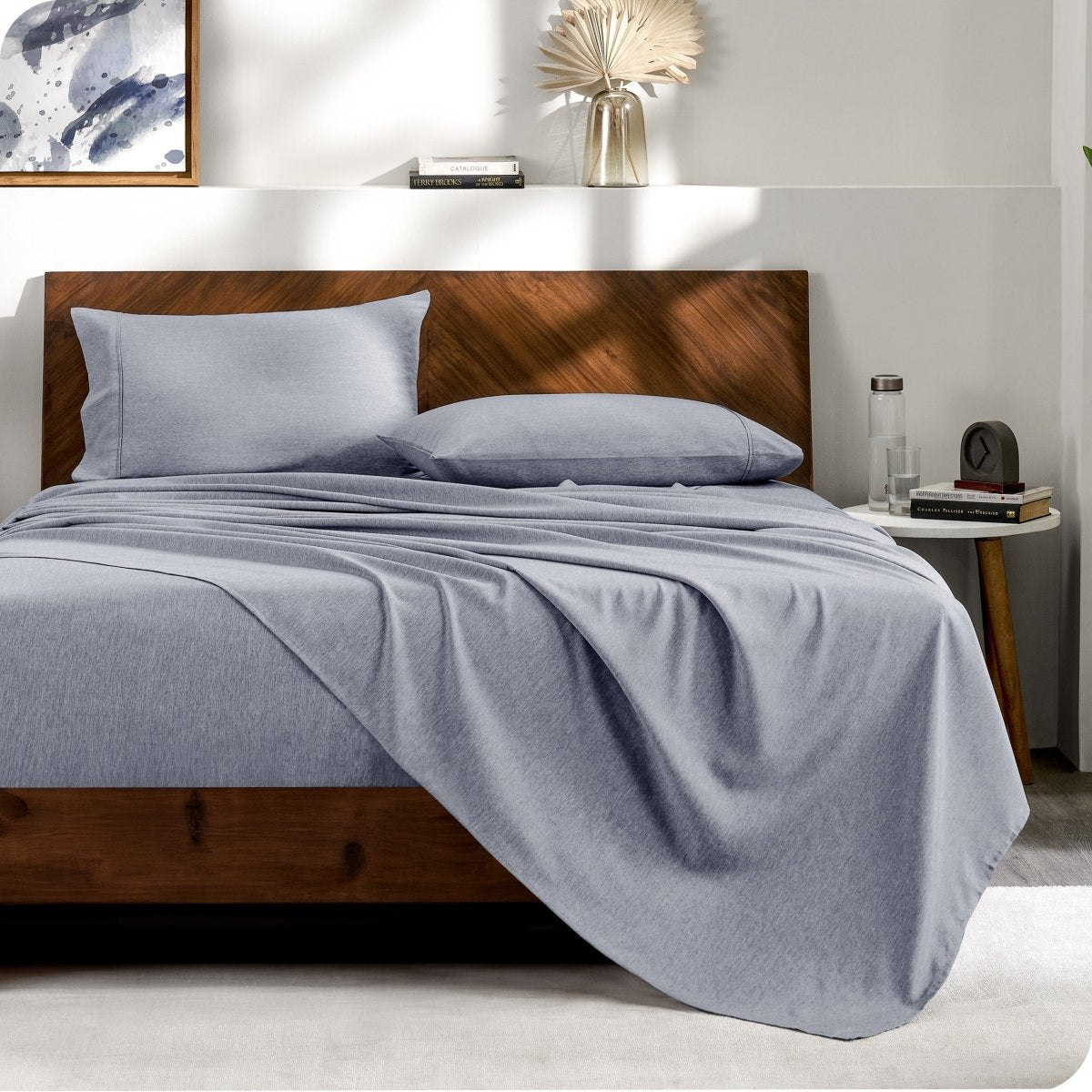 View from the end of a bed with matching sheets and pillowcases.
