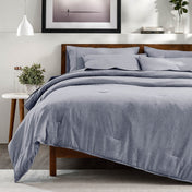 A bedroom with a side table, decor and a neatly made bed