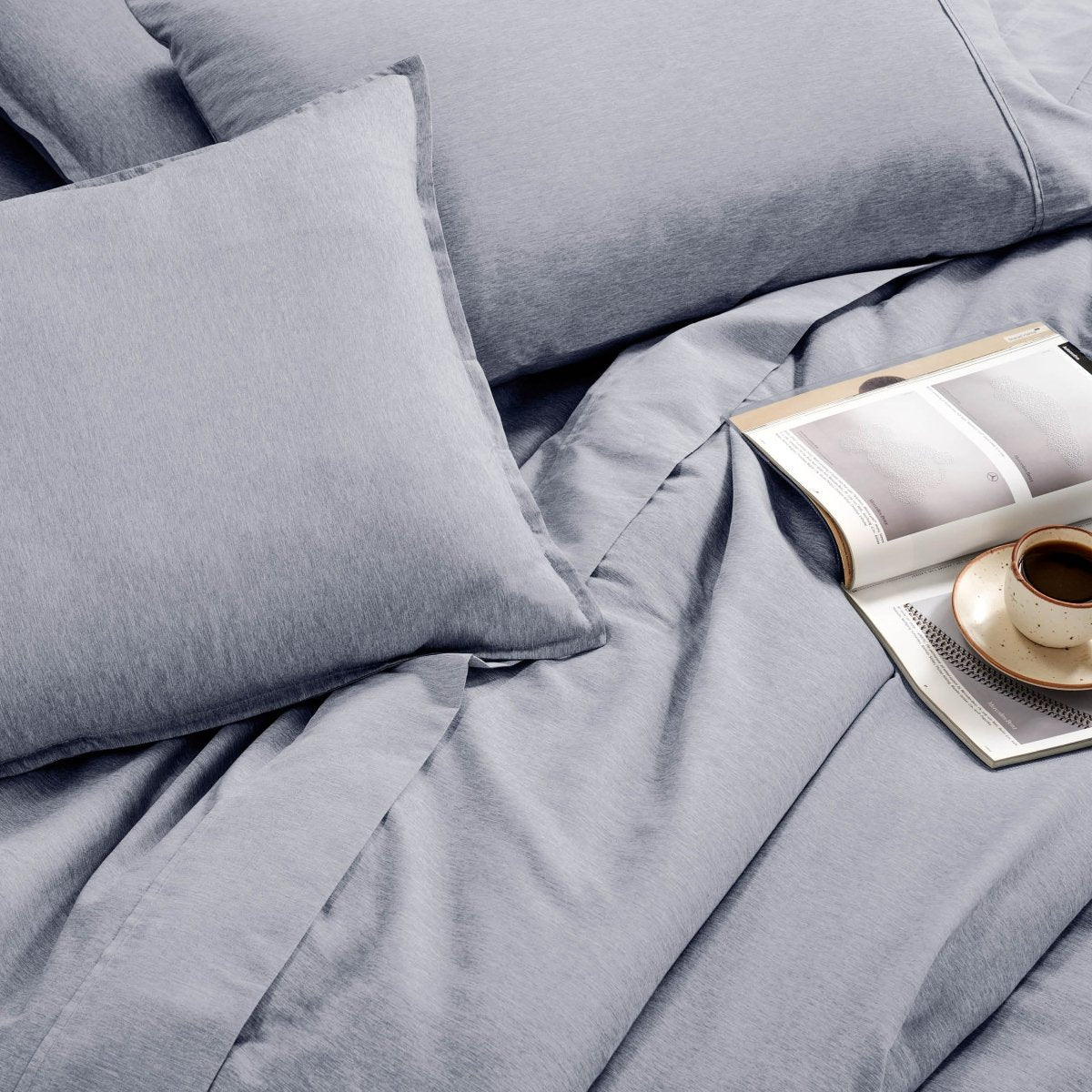 Bedding set with an open book and a cup on a saucer.