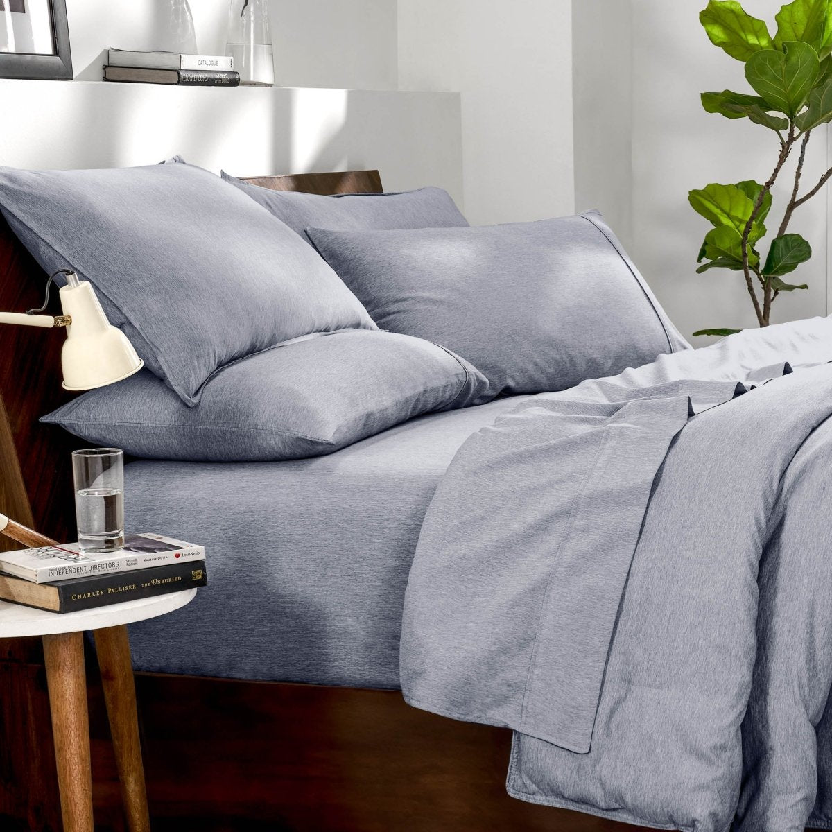 Bedding set on a bed in a bedroom with a side table and lamp.