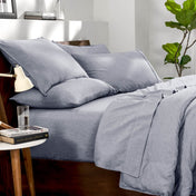 Bedding set on a bed in a bedroom with a side table and lamp.