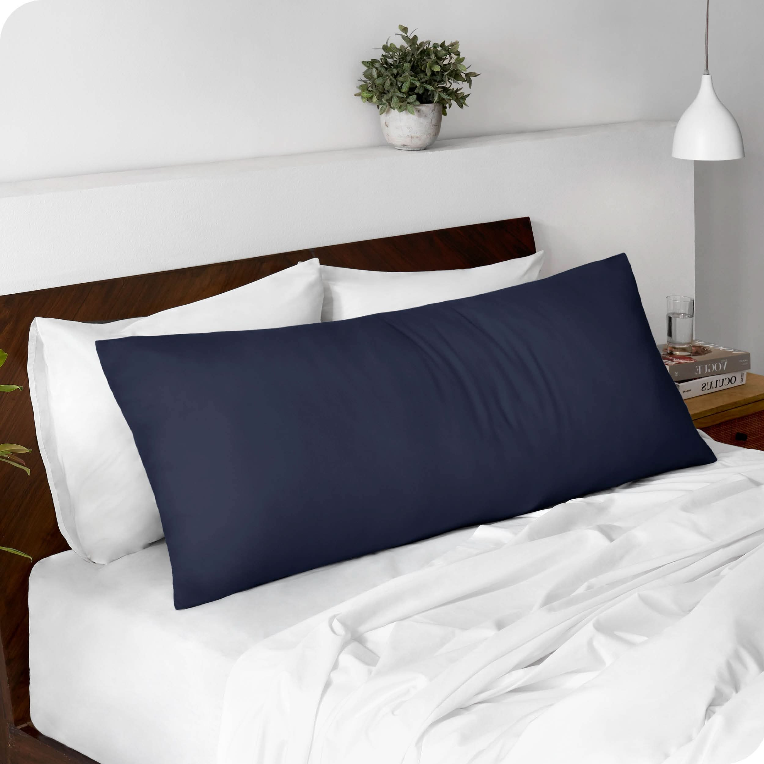 A body pillowcase on a pillow set against a headboard